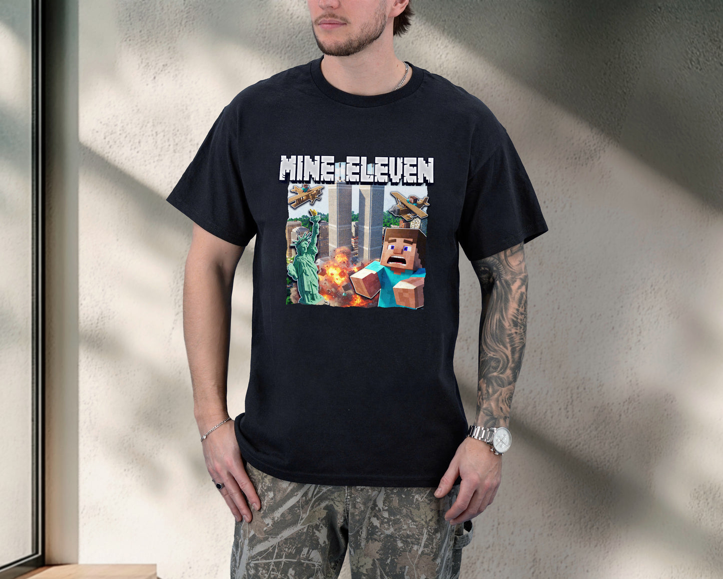 Person wearing a black t-shirt with 'MINEELEVEN' graphic design.