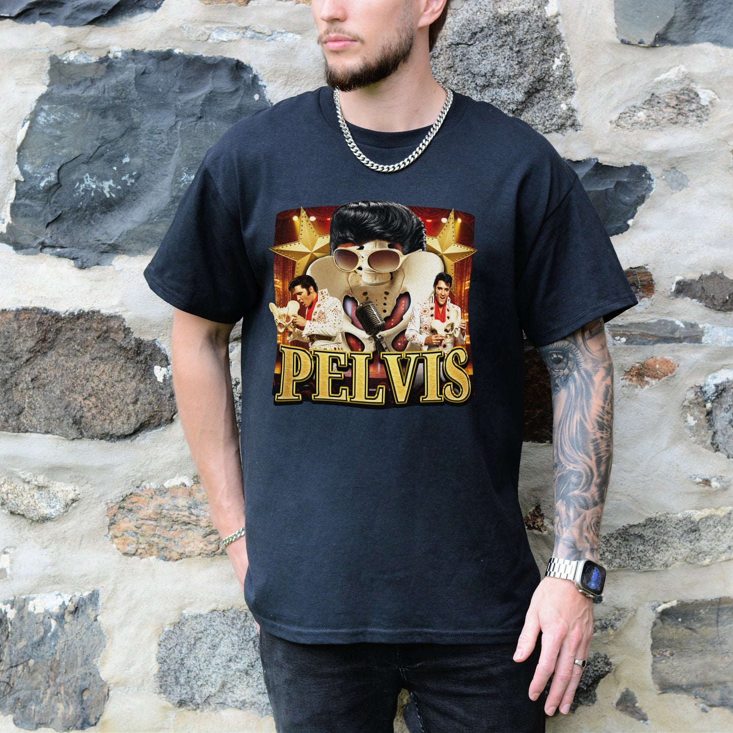 Person wearing a black t-shirt with Elvis Presley graphic and 'PELVIS' text against a stone wall background.
