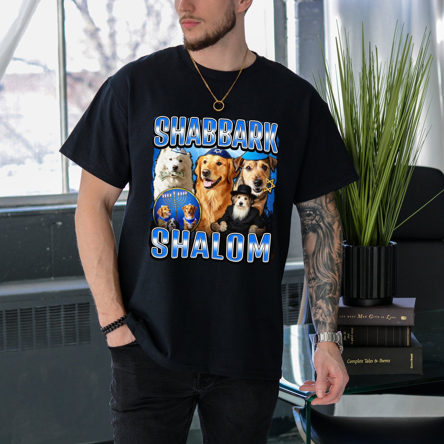 Person wearing a black t-shirt with dog illustrations and text in an indoor setting.