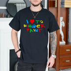 Person wearing a black t-shirt with colorful text in a room.