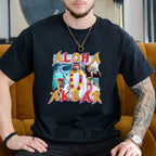 Person wearing a black t-shirt with 'Aloha Akbar' graphic design sitting on a mustard yellow couch.