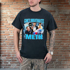 Person wearing a black t-shirt with graphic design and text against a brick wall.
