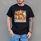 Person wearing a black t-shirt with a 'Cinnabuns' graphic design against a gray wall.