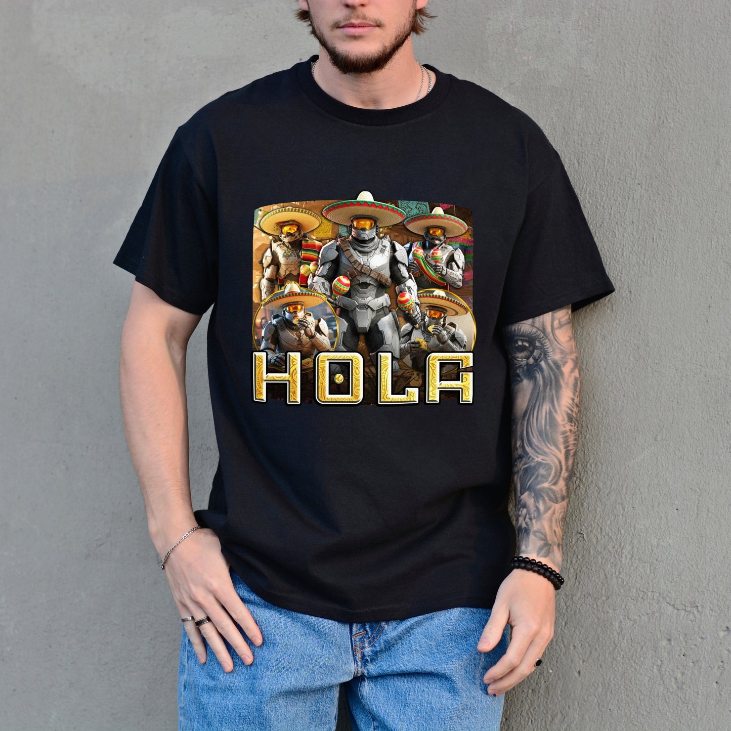 Person wearing a black t-shirt with a graphic design and the word 'HOLA' against a gray background