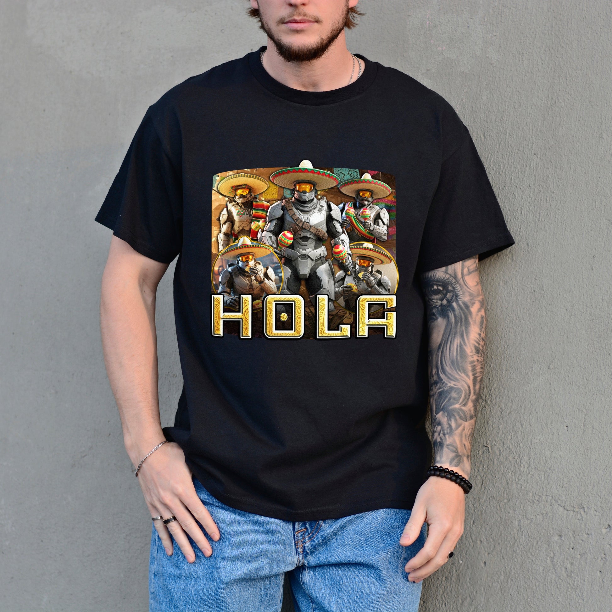 Person wearing a black t-shirt with a graphic design and the word 'HOLA' against a gray background