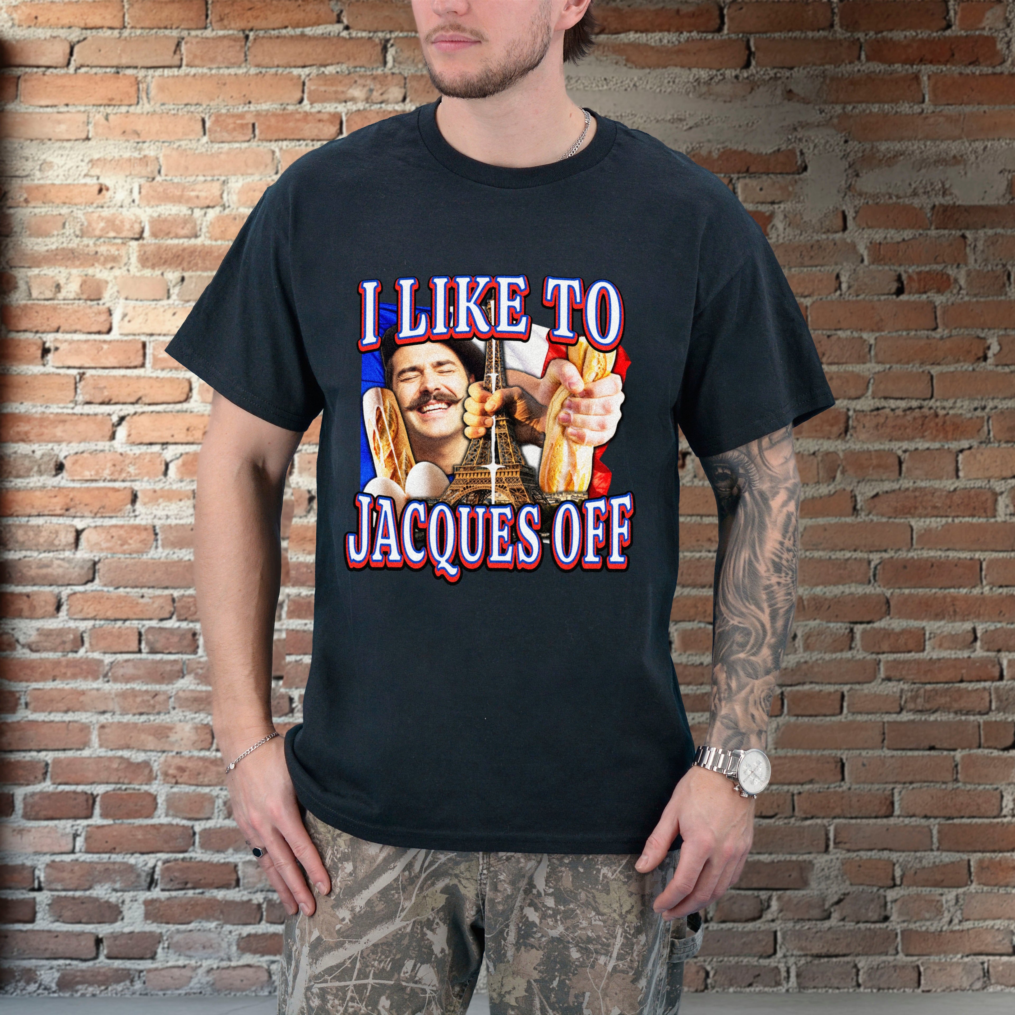 Person wearing a black t-shirt with a graphic design and text, standing against a brick wall.