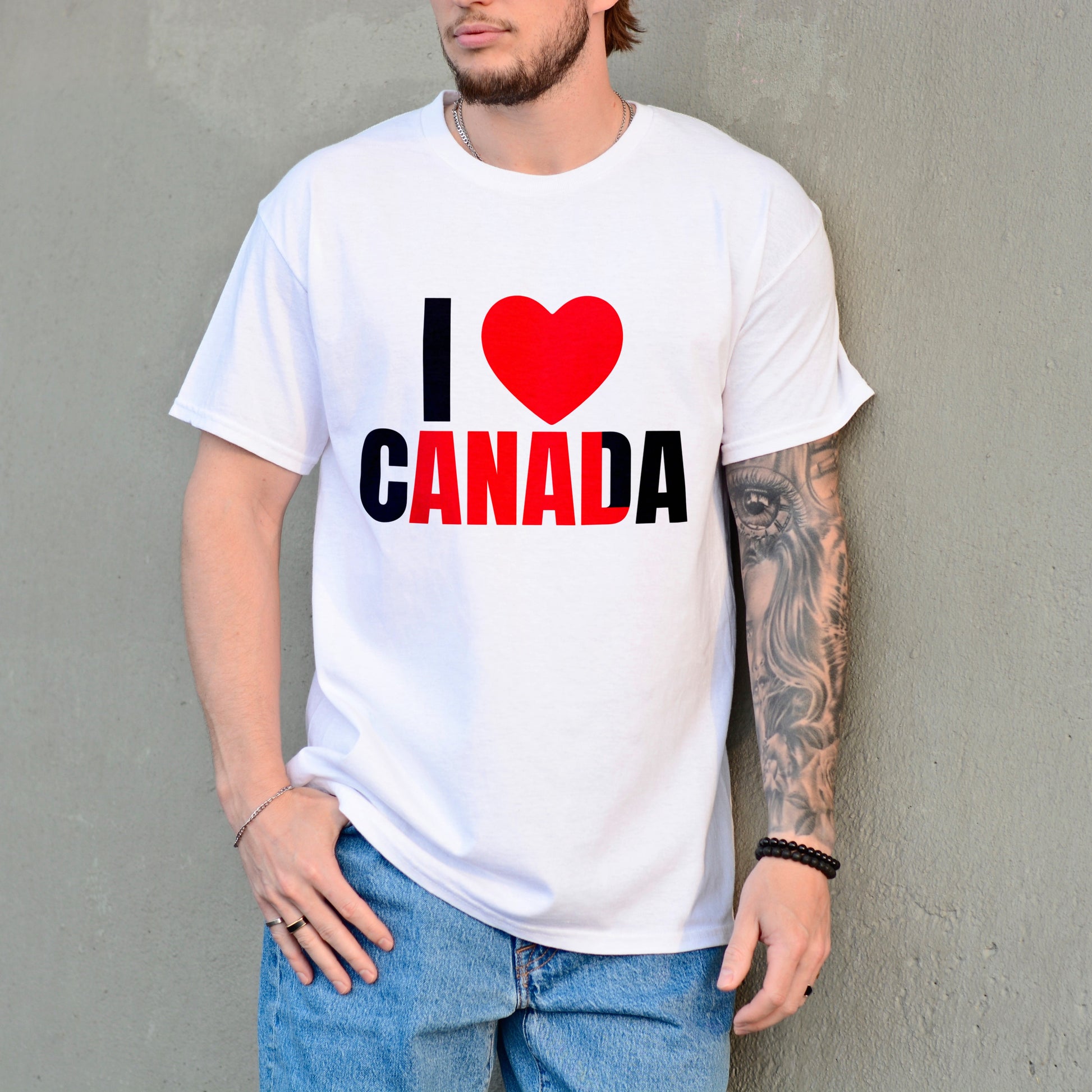 Person wearing a white t-shirt with 'I ❤️ CANADA' design against a gray wall.