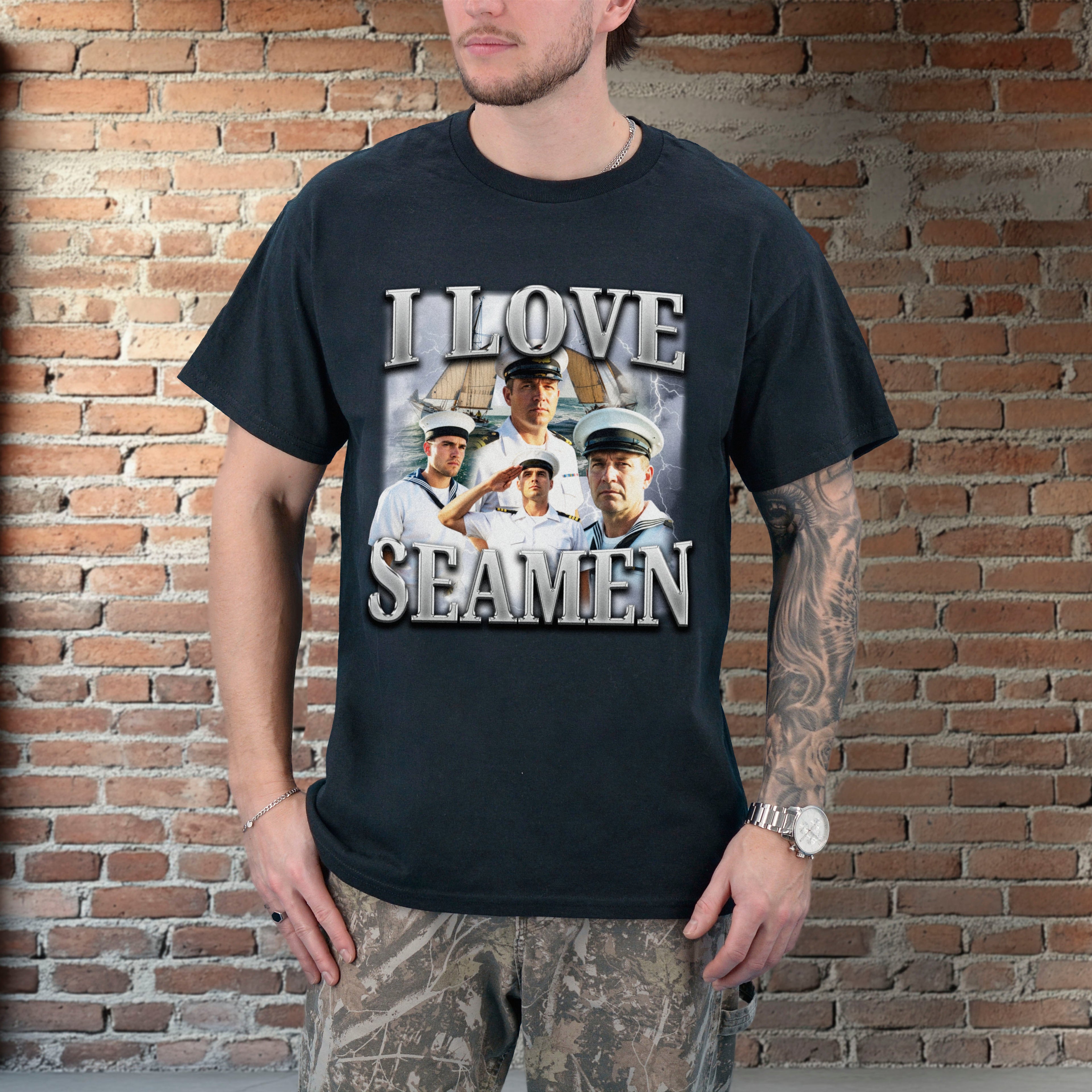 Person wearing a black t-shirt with a graphic design and text, standing against a brick wall.