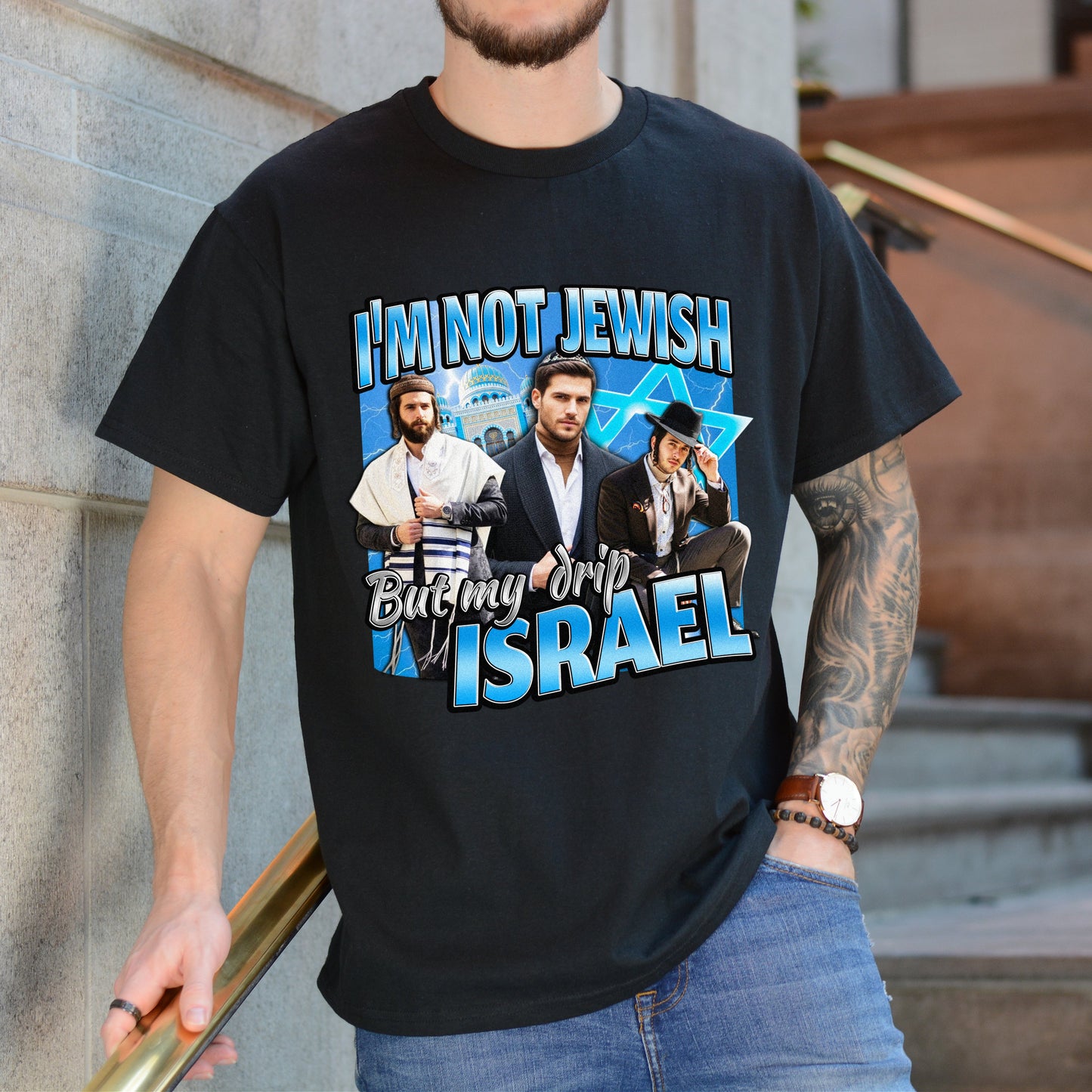 Person wearing a black t-shirt with graphic design and text, standing against a building.