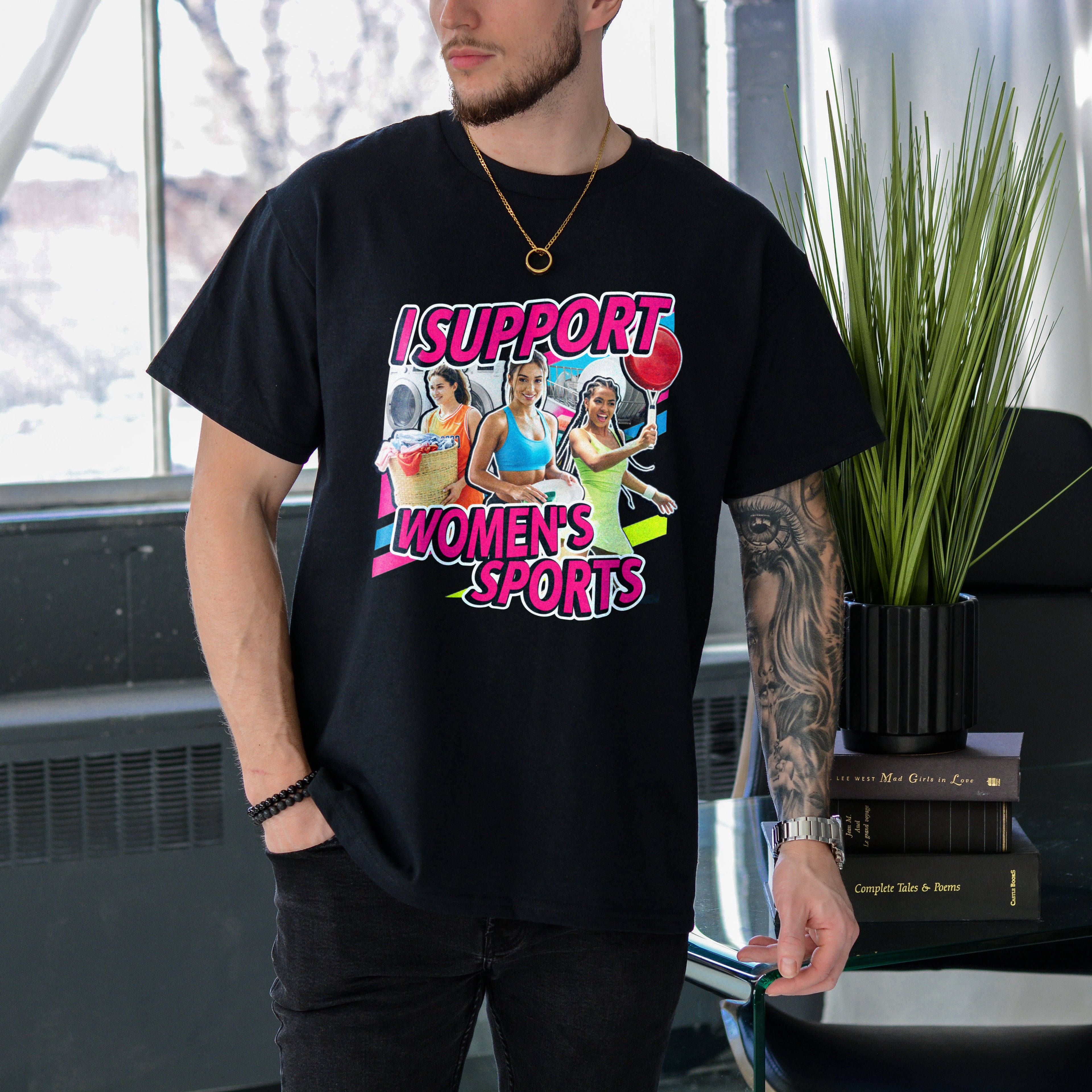 Person wearing a black t-shirt with a graphic design and text in an indoor setting.