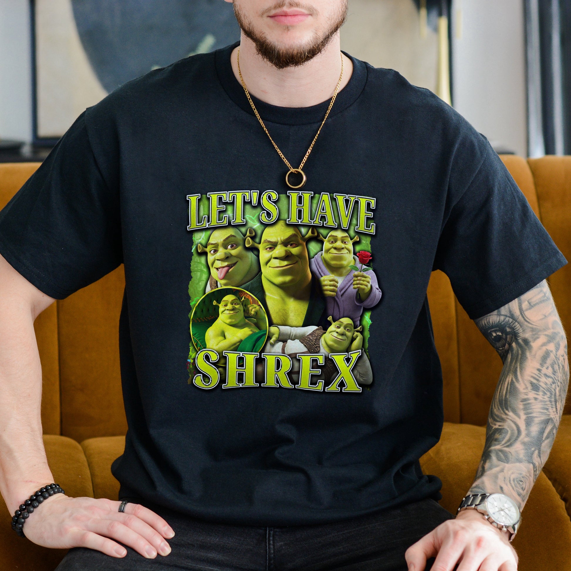 Person wearing a black t-shirt with 'Shrek' graphic design sitting on an orange couch.