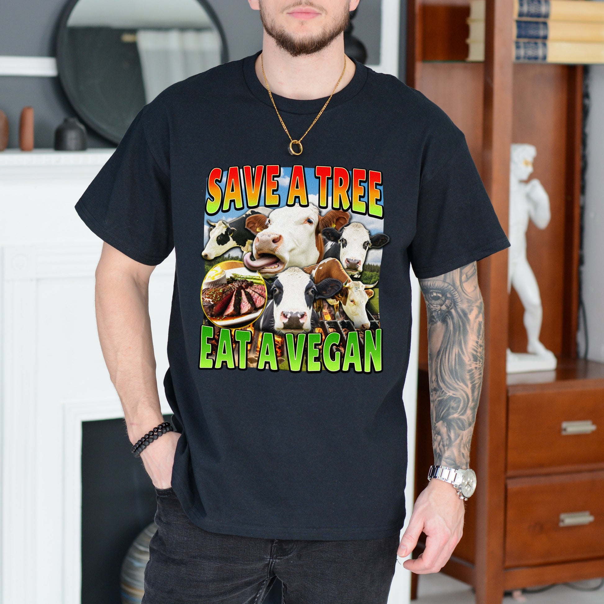 Person wearing a black t-shirt with a colorful graphic and text 'SAVE A TREE EAT A VEGAN' in a room.