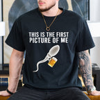 Person wearing a black t-shirt with a graphic and text in a room.